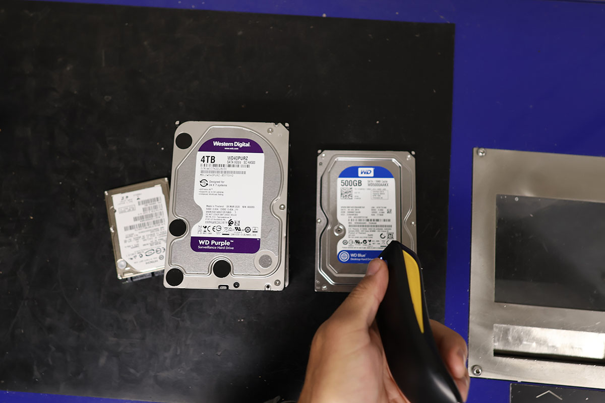 Technician scanning a hard drive serial number before destruction